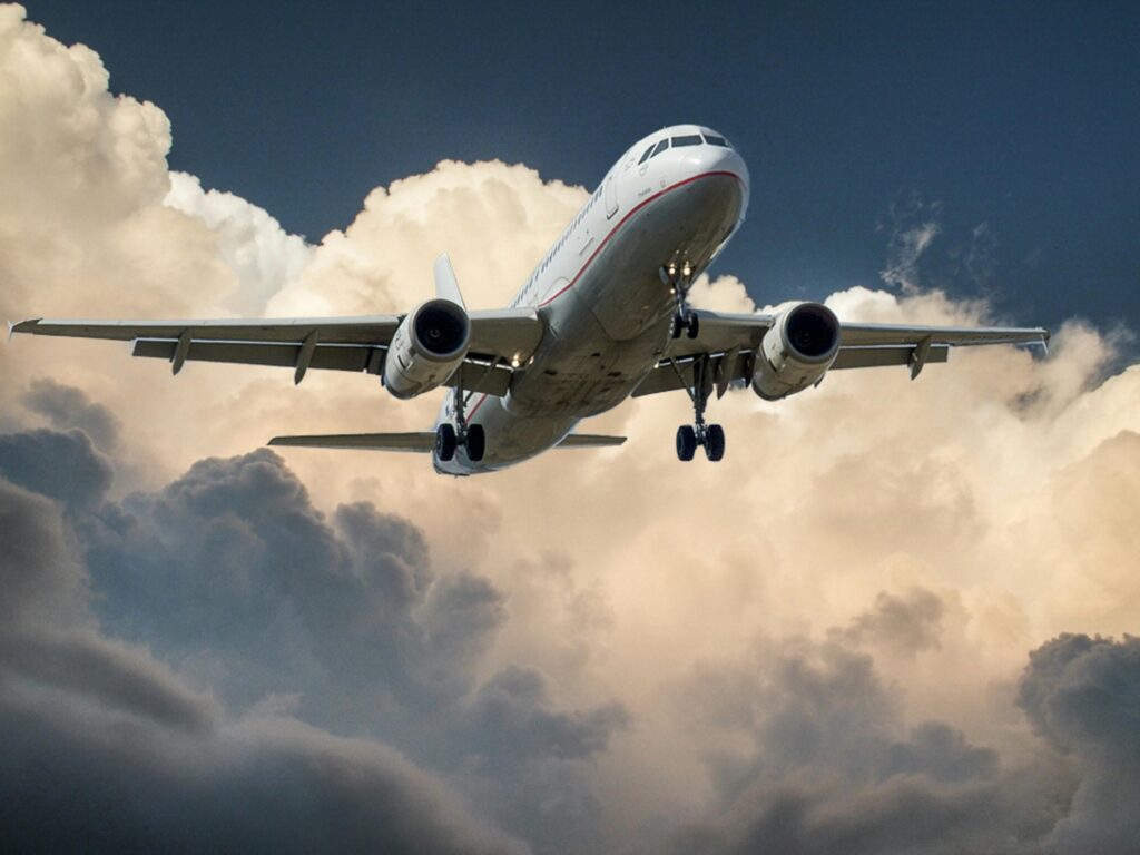 Plane flying in the sky, symbolizing weekend getaways for Erasmus students