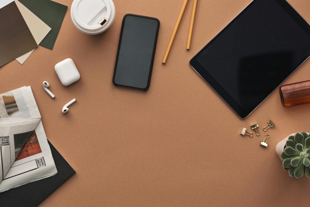 A table with Erasmus essentials including a phone, pencils, and study materials for an Erasmus semester checklist.